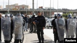 Members of the police stand guard during an anti-government protest in Tunis, Tunisia, Jan. 26, 2021. 