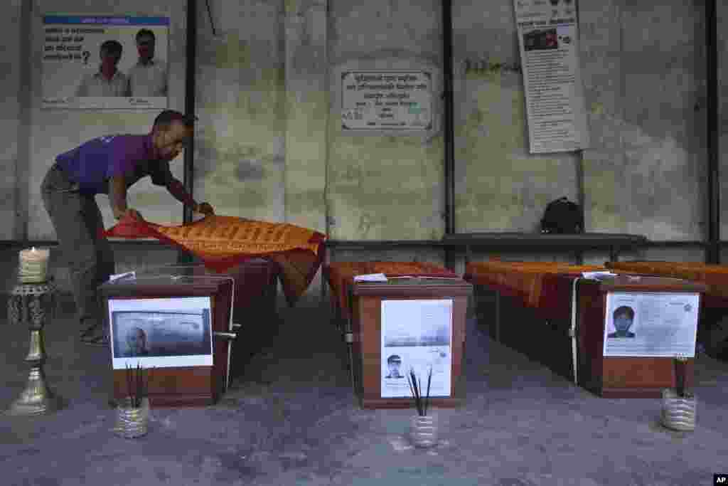 네팔 히말라야를 등반하던 한국 원정대원들이 지난 주말 눈사태로 인해 사망한 가운데 네팔 현지남성이 시신이 보관된 관 위에 스카프를 올리고 있다. 한국 외교부는 가족들의 뜻에 따라 시신은 국내로 운구돼 장례절차를 이어갈 예정이라고 밝혔다.