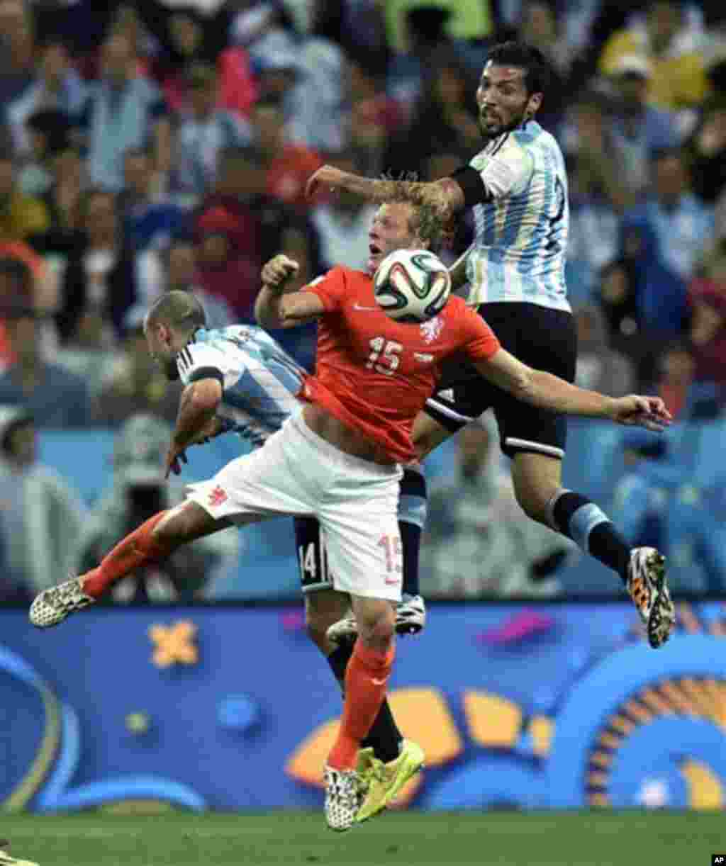 Netherlands' Dirk Kuyt is challenged by Argentina's Javier Mascherano, left, and Ezequiel Garay during the World Cup semifinal soccer match between the Netherlands and Argentina at the Itaquerao Stadium in Sao Paulo Brazil, Wednesday, July 9, 2014. (AP Ph