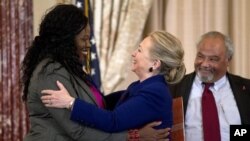 Secretary of State Hillary Rodham Clinton greets Florence Ngobeni-Allen, ambassador for the Elizabeth Glaser Pediatric AIDS Foundation during a ceremony in recognition of World AIDS Day, at the State Department in Washington, D.C., November 29, 2012.