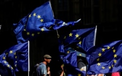 Anti Brexit protestors wave their flags opposite Parliament in London, Thursday, Aug. 29, 2019.