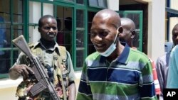 FILE - Kenya's Cult preacher Pastor Paul Nthenge Mackenzie of the Good News International church, foreground, arrives at the Shanzu Law Courts under tight security, in Mombasa, Kenya, Thursday Oct. 12. 2023.