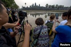 ភ្ញៀវទេសចរណ៍​ប្រមូល​ផ្តុំ​គ្នា​ដើម្បី​ថត​រូប​ប្រាសាទ​អង្គរវត្ត​ដ៏​ល្បីល្បាញ​របស់​កម្ពុជា​ក្នុង​អំឡុង​ពេល​ថ្ងៃ​រះ​នៅ ខេត្ត​សៀមរាប​កាល​ពី​ថ្ងៃ​ទី​២០ ខែ​មីនា ឆ្នាំ​២០១៥។