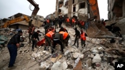 Civil defense workers and security forces search through the wreckage of collapsed buildings in Hama, Syria, Feb. 6, 2023. 