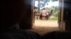 FDLR combatants playing cards with civilians in Lusoa village, North Kivu, DRC, March 28, 2015. (N. Long/VOA)