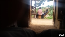 FDLR combatants playing cards with civilians in Lusoa village, North Kivu, DRC, March 28, 2015. (N. Long/VOA)