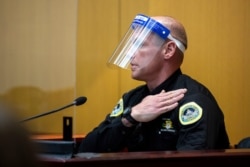 Des Moines Police Officer Luke Wilson shows where he was wearing his body camera when he arrested Des Moines Register reporter Andrea Sahouri during a protest, at her trial in Des Moines, Iowa, March 10, 2021. (Kelsey Kremer/Des Moines Register)