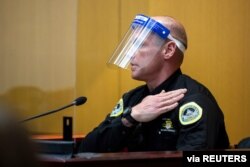 Des Moines Police Officer Luke Wilson shows where he was wearing his body camera when he arrested Des Moines Register reporter Andrea Sahouri during a protest, at her trial in Des Moines, Iowa, March 10, 2021. (Kelsey Kremer/Des Moines Register)