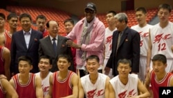 Dennis Rodman chụp ảnh cùng với các vận động viên bóng rổ và các viên chức chính phủ trong một buổi luyện tập, 20/12/13