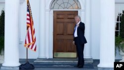 President-elect Donald Trump gives the thumbs-up after Mitt Romney leaves Trump National Golf Club Bedminster in Bedminster, N.J., Nov. 19, 2016. 