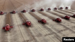 FILE - Workers harvest soybeans in a farm in the city of Tangara da Serra, Brazil, March 27, 2012. 