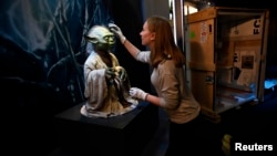 Nicole Manis, of the Lucas Museum of Narrative Art, unpacks a Yoda puppet, Nov. 8, 2016, used in the sci-fi movies. The "Star Wars Identities" exhibition begins next week in London.
