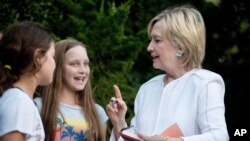 Hillary Clinton habla con jóvenes mientras firma un autógrafo luego de un evento de recaudación de fondos para su campaña presidencial en una residencia privada en Sagaponack, N.Y., el 30 de agosto. 