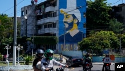 ARCHIVO: Vista de San Salvador, la capital de El Salvador, con una imagen del presidente Nayib Bukele dibujada en la fachada de un edificio residencial el 17 de noviembre de 2023.