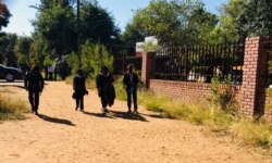 Students walk near a school as classes are cancelled in response to a surge of new COVID-19 cases, in Gaborone, Botswana. (Mqondisi Dube/VOA)