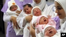 FILE - Nurses hold newborn babies in Sidon, Lebanon, Oct. 31, 2011. 