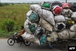 Waste collectors transport plastic scrap for recycling in the suburbs of Hanoi, Vietnam.