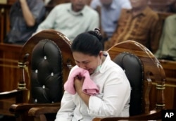 FILE - Ethnic Chinese woman Meiliana weeps during her sentencing hearing at a district court in Medan, North Sumatra, Indonesia, Aug. 21, 2018.