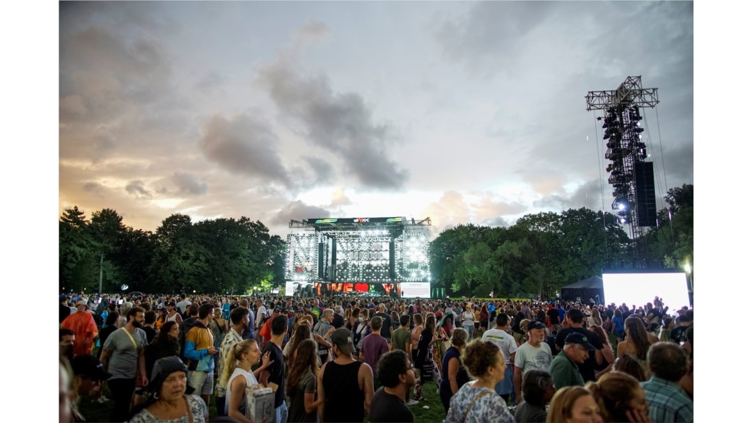 People exit the field to try to find shelter as a screen shows information about severe weather approaching the area after the “We Love NYC" concert at Central Park was canceled, in New York City, Aug. 21, 2021.