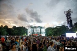 People exit the field to try to find shelter as a screen shows information about severe weather approaching the area after the “We Love NYC" concert at Central Park was canceled, in New York City, Aug. 21, 2021.