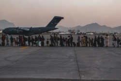 FILE - Evacuees wait to board a Boeing C-17 Globemaster III during an evacuation at Hamid Karzai International Airport, Kabul, Afghanistan, Aug. 23. (US Marine Corps photo)