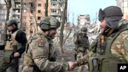 Na ovoj fotografiji preuzetoj sa video snimka koji je 25. februara 2024. objavio na telegramskom kanalu šefa regije Donjeck pod ruskom kontrolom Denisa Pušilin, Denis Pušilin, u prednjem planu lijevo, pozdravlja vojnika u Avdijevki, u istočnoj Ukrajini .