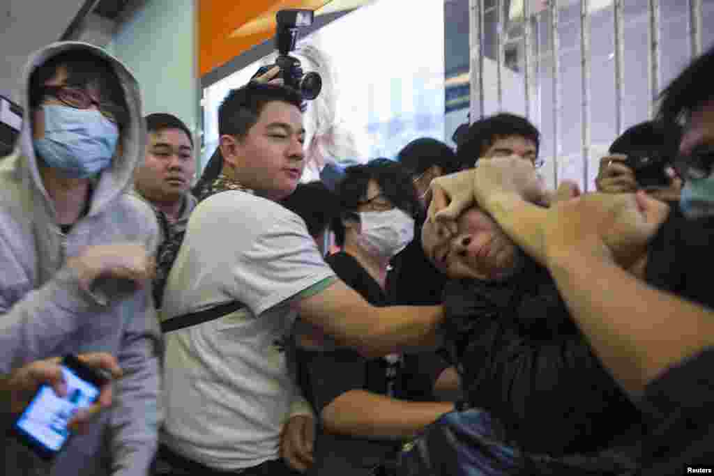 معترضان در جریان تظاهراتی در داخل یک مرکز خرید در هنگ کنگ مردی (راست) را مهار می&zwnj;کنند که ادعا می&zwnj;شد معترضان را به باد کتک گرفته است. بنا به گزارش رادیوی دولتی، تظاهرکنندگان ضد سرزمین اصلی چین به معامله&zwnj;گران موازی و پلیس اعتراض می&zwnj;کردند.&nbsp;