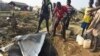 Displaced people draw water from a hole dug in the ground in the United Nations camp for displaced people in the capital Juba, South Sudan, Jan. 19, 2016.