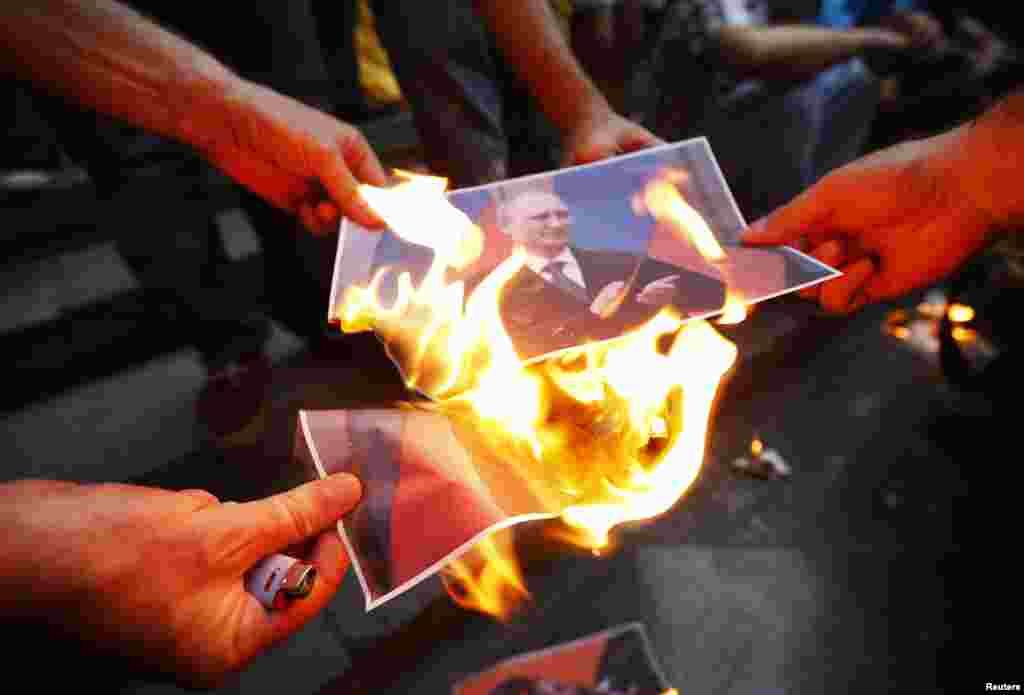 Protesters burn portraits of Russian President Vladimir Putin during a rally in support of Ukraine in Tbilisi, Georgia.