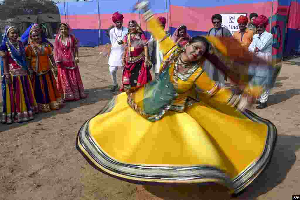 Performers wearing traditional outfits from Rajasthan state dance during a press preview of tableaux participating in the forthcoming Republic Day parade in New Delhi.