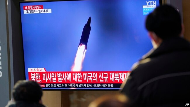 FILE - People watch a TV screen showing a news program reporting about a North Korea missile launch with a file image, at a train station in Seoul, South Korea, Jan. 14, 2022.