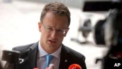 FILE - Hungarian Foreign Minister Peter Szijjarto speaks with the media as he arrives for a meeting of EU foreign ministers at the EU Council building in Luxembourg, Sept. 4, 2015