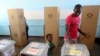  FILE - A child keeps an eye on his father who casts his vote at a polling station in Harare, Zimbabwe, Monday, July, 30, 2018.