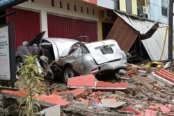 A damaged car and buildings are seen following an earthquake in Mamuju, West Sulawesi province, Indonesia, Janu. 15, 2021. (Antara Foto/Akbar Tado via Reuters)