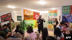 FILE - Pro-Palestinian environmental activists participate in a sit-in demonstration at the Expo City in Dubai on November 30, 2023, during the COP28 United Nations climate summit.