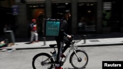 A food delivery cyclist carries a Deliveroo bag in Madrid, Spain