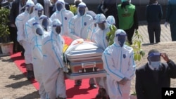 FILE - Health officials carry the coffin of Zimbabwean minister Perence Shiri, who died of Covid-19, during his burial in Harare, July, 31, 2020.