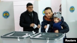 Voters cast ballots during a presidential election at a polling station in Chisinau, Moldova, Nov. 13, 2016.