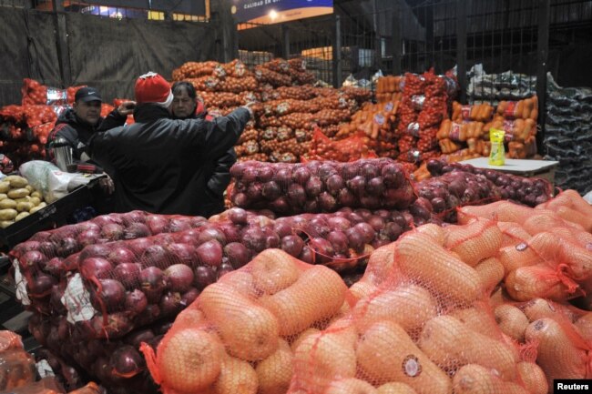 People talk at the Mercado Central, the city's largest wholesale central market which receives produce from the entire country, outside of Buenos Aires, Argentina on June 23, 2022. (REUTERS/Mariana Nedelcu)