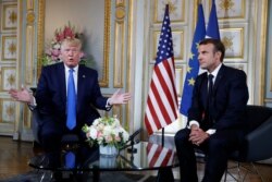 FILE - President Donald Trump and French President Emmanuel Macron meet in Caen, France, June 6, 2019.