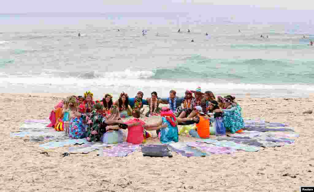 Prince Harry, Duke of Sussex and Meghan, Duchess of Sussex talk to members of OneWave, an awareness group for mental health and wellbeing at South Bondi Beach in Sydney, Australia.