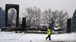 A worker walks past a destroyed home in Louisville, Colorado, Dec. 31, 2021.