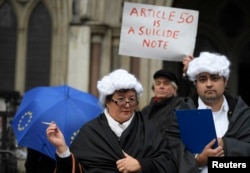 FILE - Demonstrators stand outside the High Court during a legal challenge to force the British government to seek parliamentary approval before starting the formal process of leaving the European Union, in London, Britain, Oct. 13, 2016.
