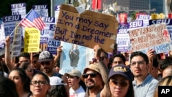 Supporters of the Deferred Action for Childhood Arrivals, or DACA chant slogans and hold signs while joining a Labor Day rally in downtown Los Angeles on Sept. 4, 2017. 