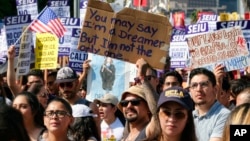 Supporters of the Deferred Action for Childhood Arrivals, or DACA chant slogans and hold signs while joining a Labor Day rally in downtown Los Angeles on Sept. 4, 2017. 