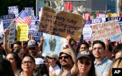 FILE - Supporters of the Deferred Action for Childhood Arrivals, or DACA, chant slogans and hold signs in downtown Los Angeles, Sept. 4, 2017.