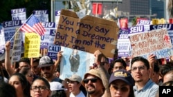 FILE - Supporters of the Deferred Action for Childhood Arrivals program chant and hold signs while joining a Labor Day rally in downtown Los Angeles, Sept. 4, 2017. 