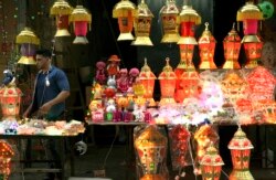 Seorang pedagang Palestina berdiri di antara lampion Ramadhan tradisional yang menyala sambil menunggu pelanggan di pasar utama di Kota Gaza, Jumat 3 Juni 2016. (Foto: dok).