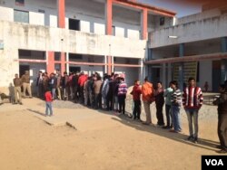 Voters wait in long lines outside schools and colleges that have been turned into polling stations will deliver a crucial verdict on the popularity of Prime Minister Narendra Modi half way through his term. (A. Pasricha/VOA)