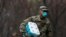 A member of Joint Task Force 2 wears a face mask while carrying paper towels in New Rochelle, New York, March 23, 2020.